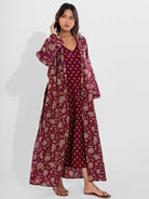 Woman wearing a vine moca floral dress with a matching long coat on a white background